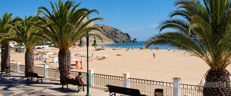 The beach of Praia da Luz with view to the black rock Rocha Negra