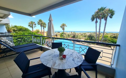Möblierter Balkon mit Blick auf Pool und Meer