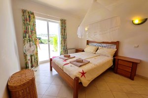 Schlafzimmer mit Doppelbett, Heizung, Ventilator und Blick auf den Spielplatz