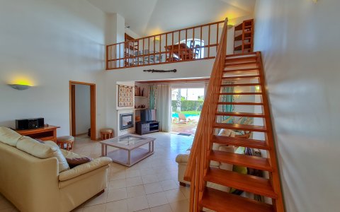 Helles Wohnzimmer mit Blick auf den Pool und Garten